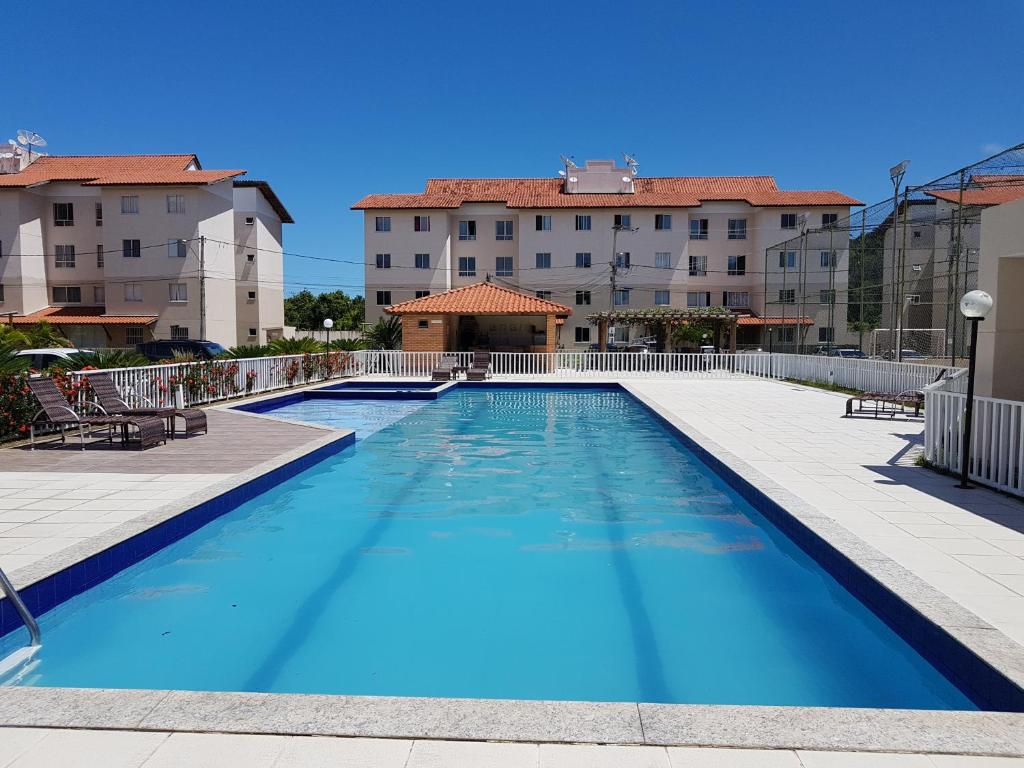 ein großer blauer Pool mit Gebäuden im Hintergrund in der Unterkunft Apartamento Modus Vivendi in Ilhéus
