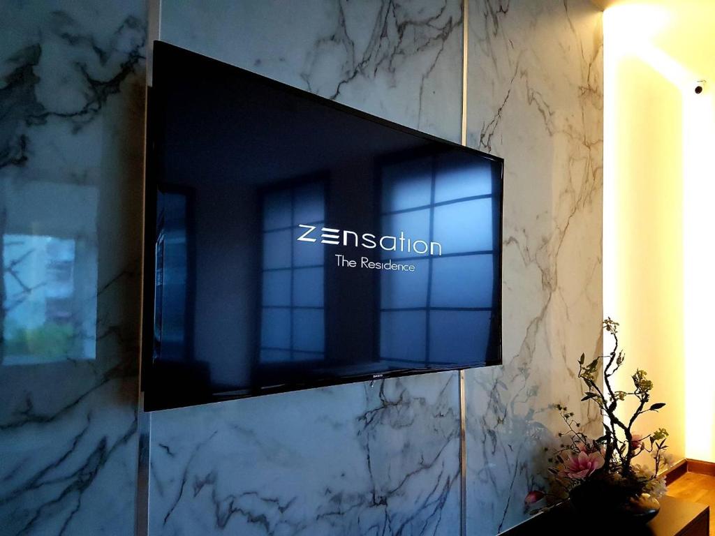 A close view of the residence-branded TV wall with marble-pattern cladding.