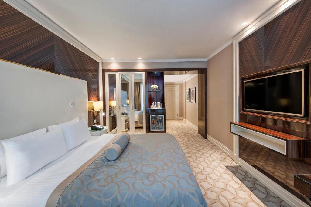 a bedroom with a large bed and a flat screen tv at Elite World Istanbul Florya in Istanbul