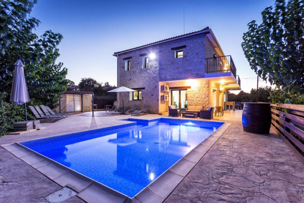 una casa con piscina frente a un edificio en Villa Nikolina, en Droushia