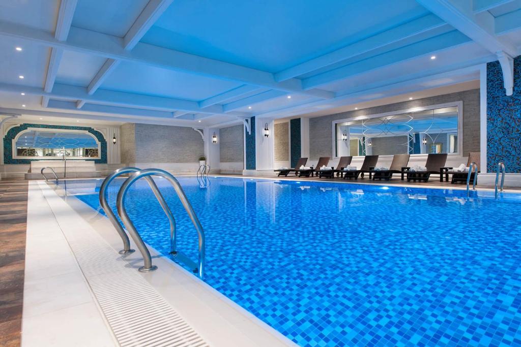 a large swimming pool with chairs in a hotel at Elite World Istanbul Florya in Istanbul