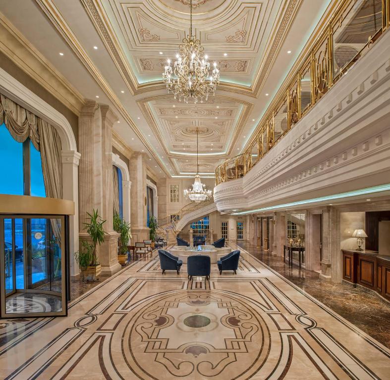 a large lobby with a chandelier and a table and chairs at Elite World Istanbul Florya in Istanbul