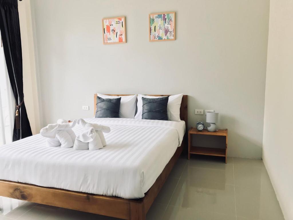 a bedroom with a bed with two white towels on it at Snooze Inn Phuket in Ban Pa Khlok