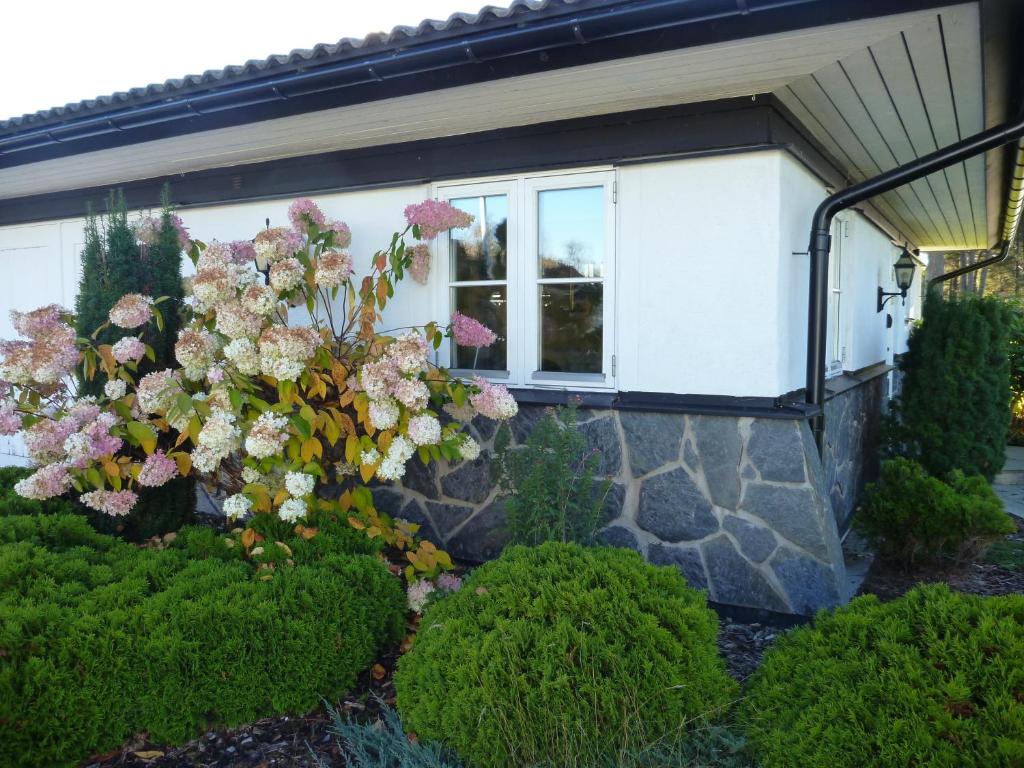 a house with a window and flowers in front of it at Hammaröstugan in Hammarö