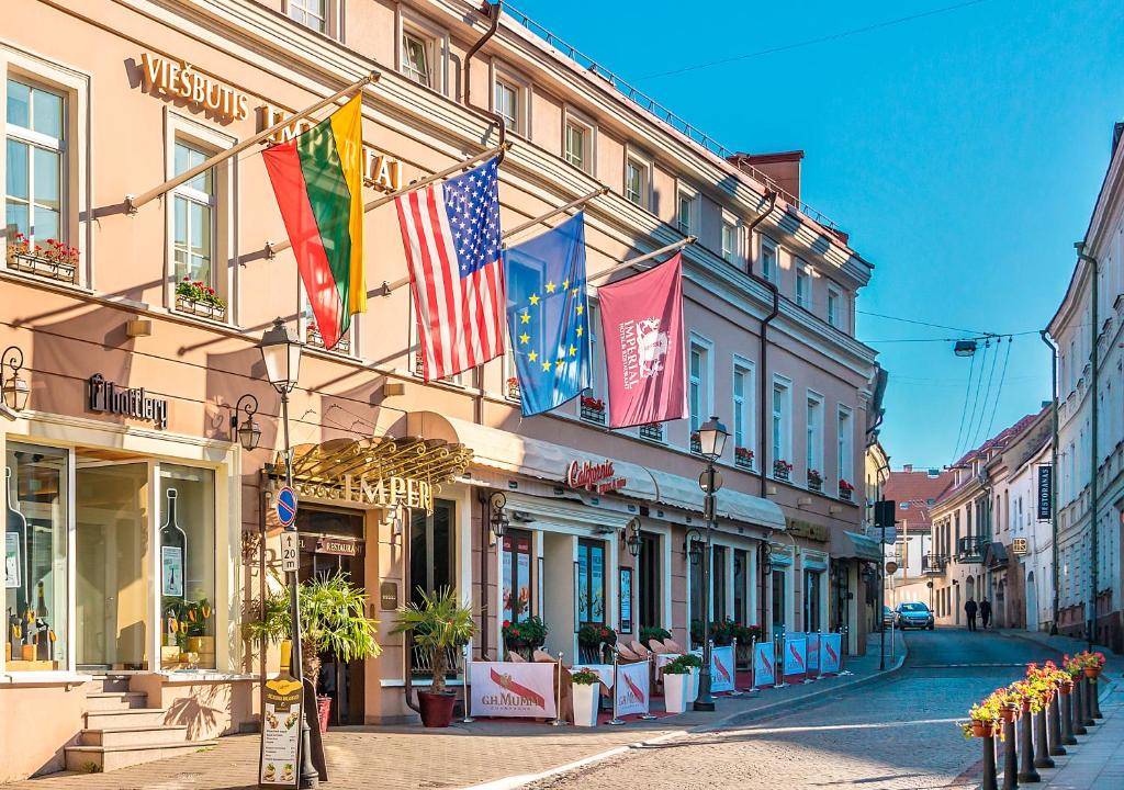 uma rua com bandeiras na lateral de um edifício em Imperial Hotel & Restaurant em Vilnius