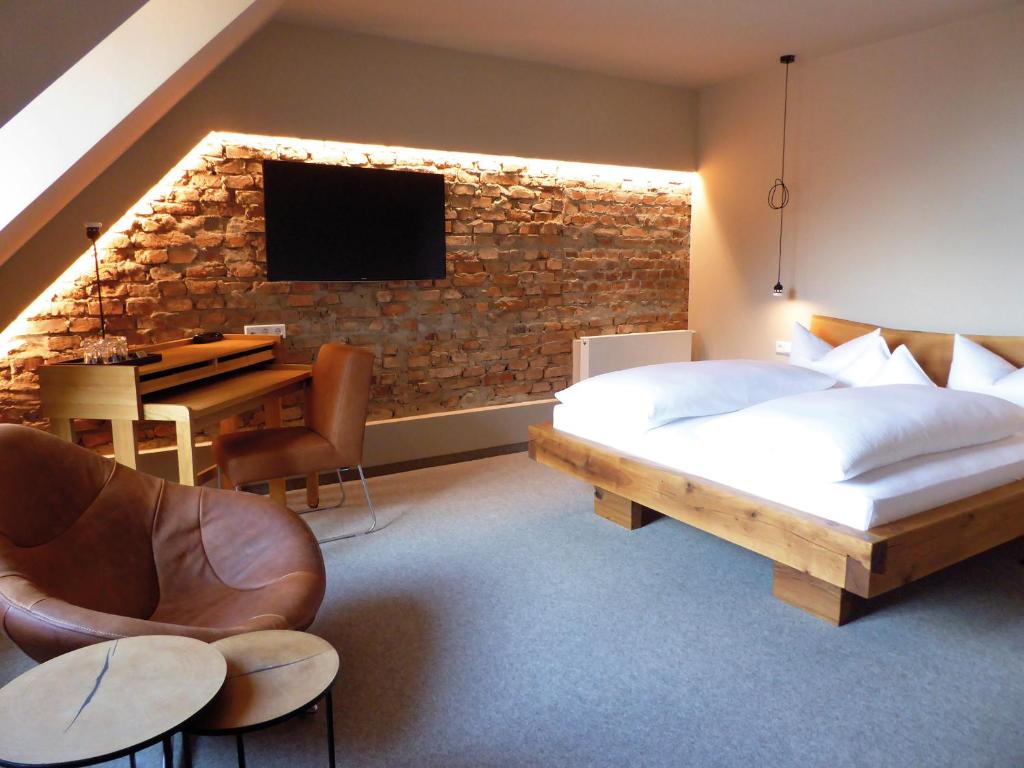 a bedroom with a bed and a desk and a television at Berghotel Sammüller in Neumarkt in der Oberpfalz
