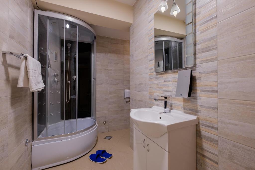 a bathroom with a toilet and a sink and a shower at Airport Hotel Garni in Belgrade