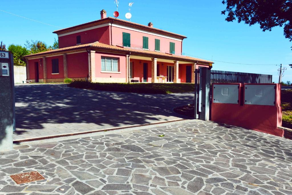 una casa roja con una entrada delante de ella en Rinaldi House, en Torriana