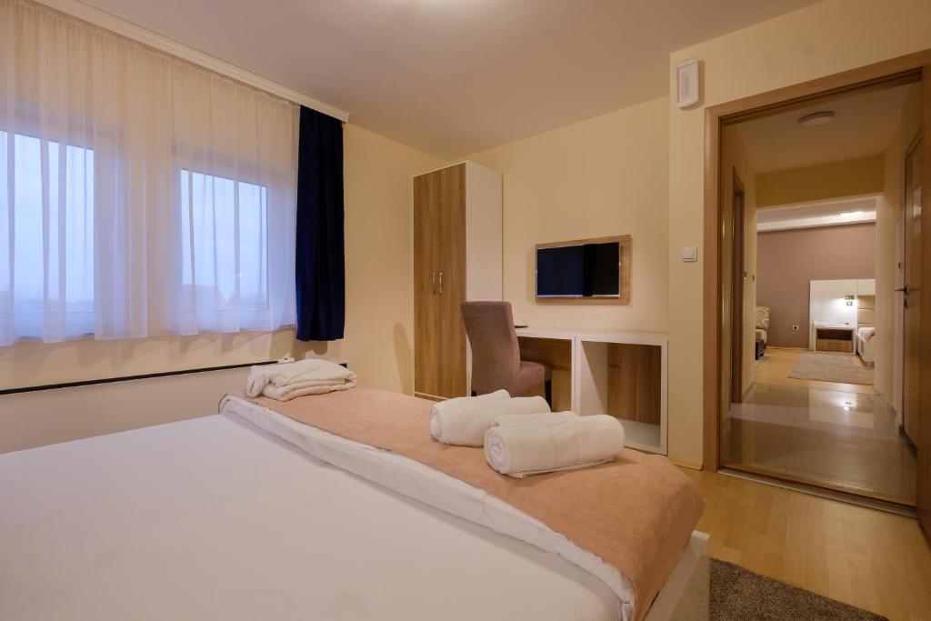 a bedroom with a large bed with white towels on it at Airport Hotel Garni in Belgrade