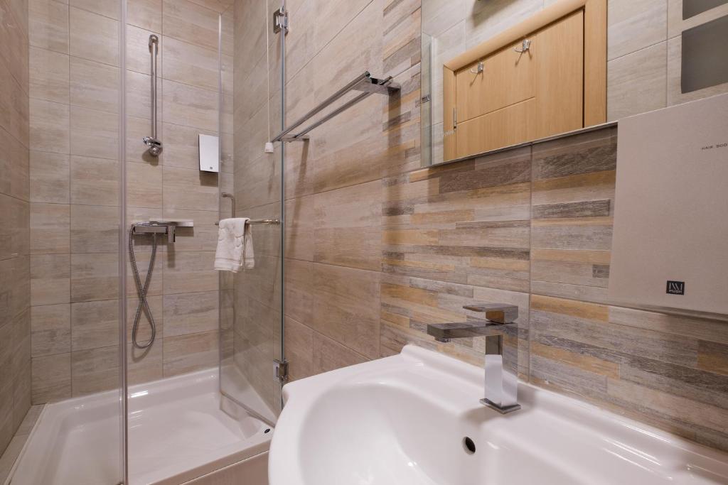 a bathroom with a sink and a shower at Airport Hotel Garni in Belgrade