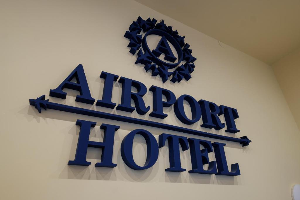 a sign for an airport hotel hanging on a wall at Airport Hotel Garni in Belgrade