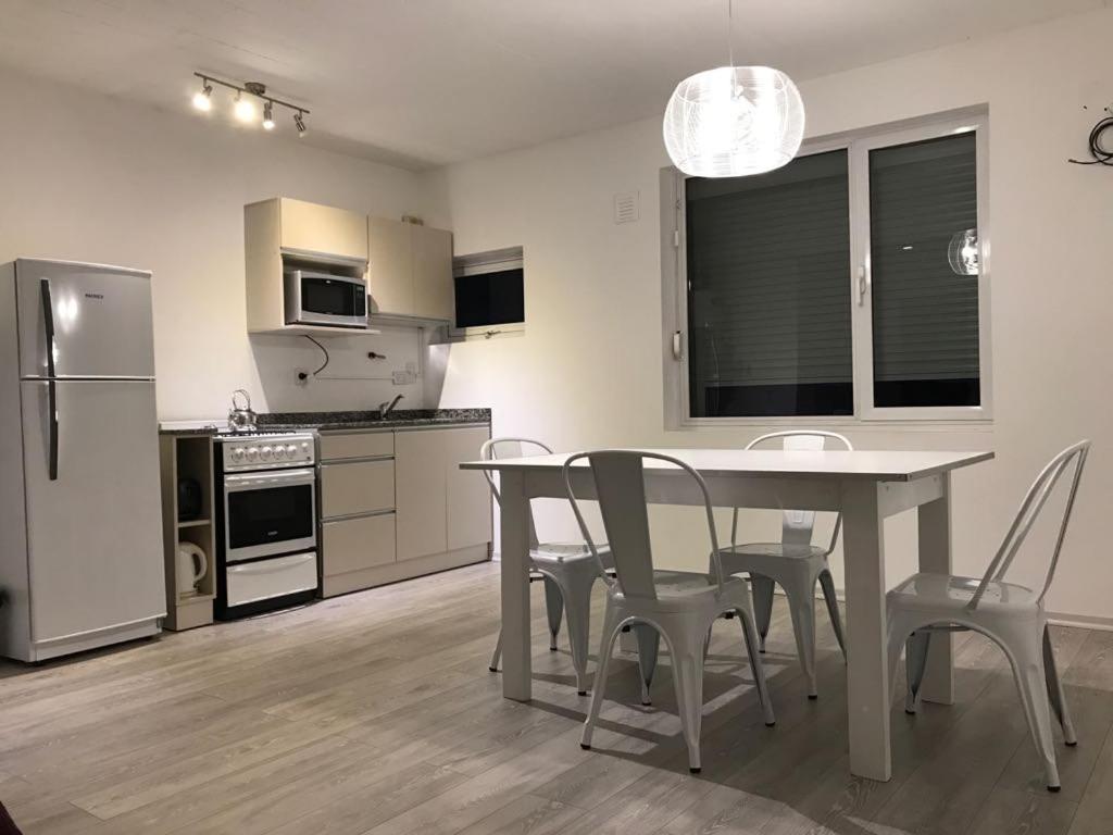 a kitchen and dining room with a table and chairs at Departamento Centro Neuquen in Neuquén