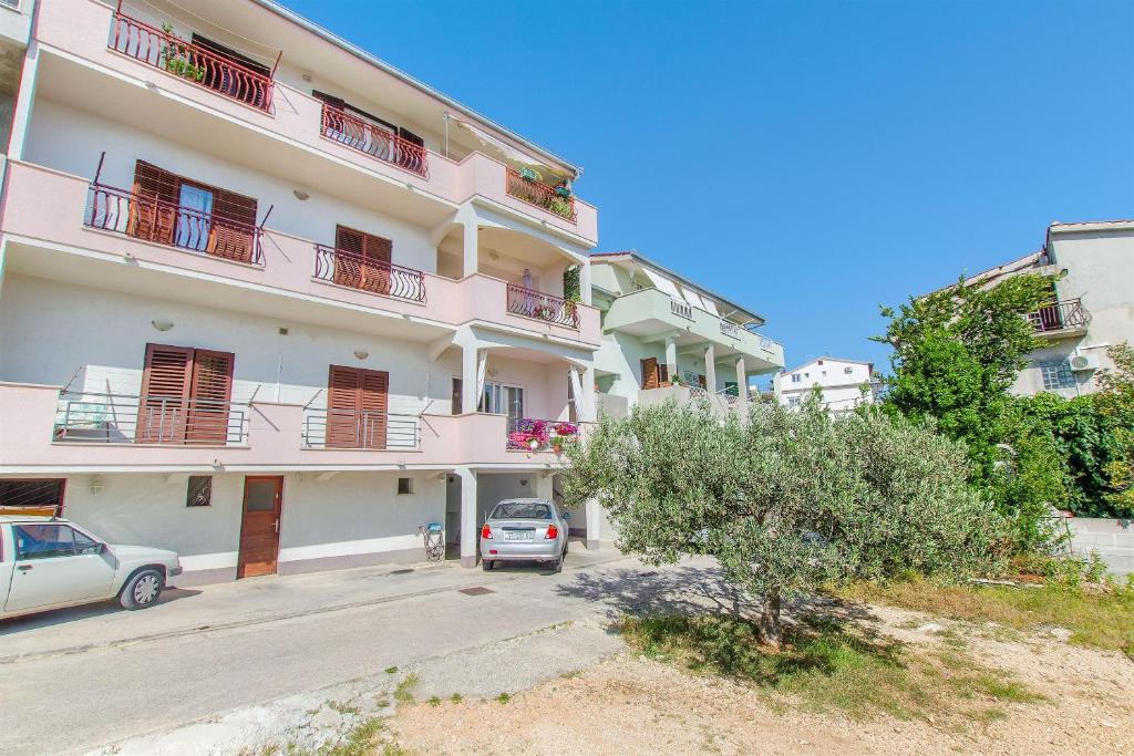 a large white building with cars parked in front of it at Apartment Jordan in Duće