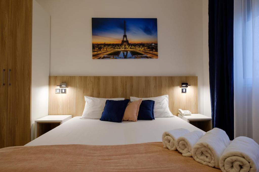 a bedroom with a bed and a picture of the eiffel tower at Airport Hotel Garni in Belgrade
