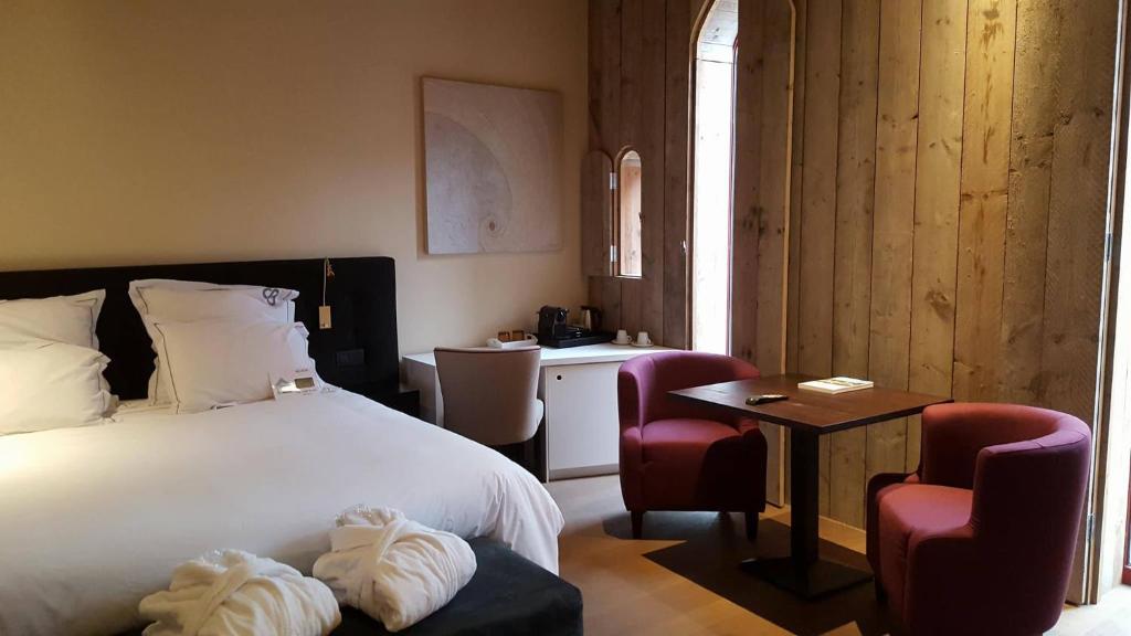 a bedroom with a bed and a table and two chairs at B&amp;B Huize Briers in Bilzen