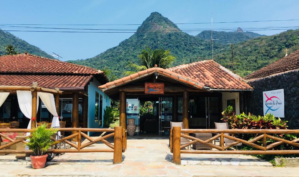 a restaurant with a mountain in the background at Pousada Recreio Da Praia in Abraão