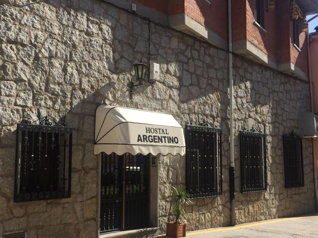 toldo ao lado de um edifício de pedra em Hostal Argentino em Béjar