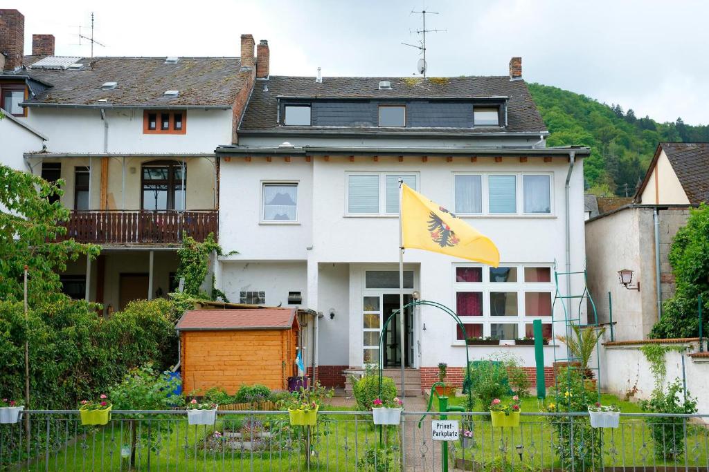 una casa blanca con una bandera amarilla delante de ella en Niedersburger Eck, wandern, radfahren, genießen, erholen, en Boppard