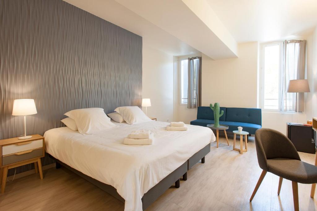 - une chambre avec un grand lit et 2 serviettes dans l'établissement Hotel Restaurant des Maures, à Collobrières