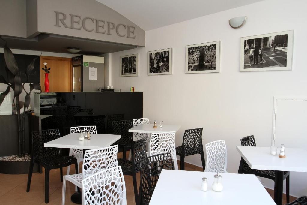 une salle à manger avec des tables et des chaises blanches dans l'établissement Penzion Markéta Chrudim, à Chrudim