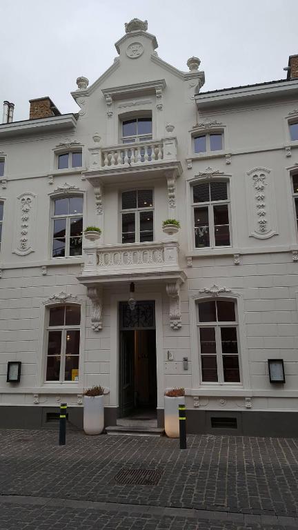 a white building with a balcony on top of it at B&amp;B Huize Briers in Bilzen
