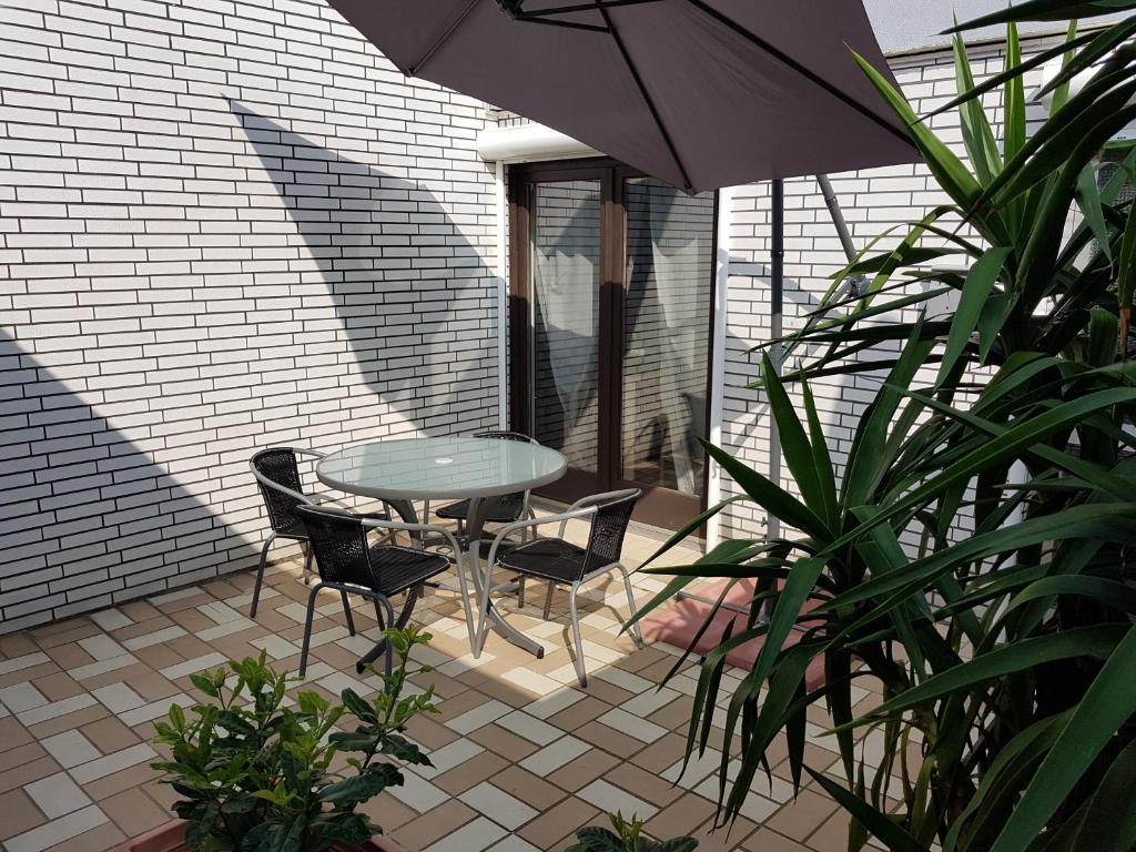 patio con tavolo, sedie e ombrellone di Appartement Stein a Fritzlar
