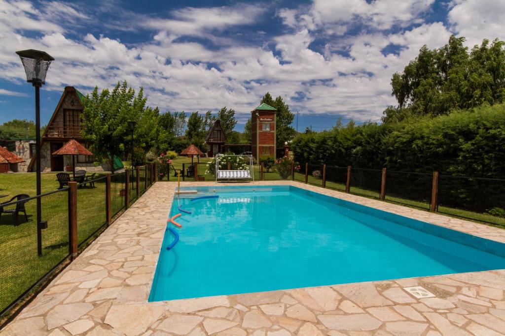 a swimming pool in a yard with a fence at Las Encinas in Potrero de los Funes