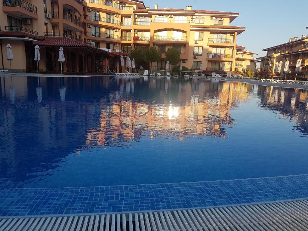 een groot zwembad met water voor sommige gebouwen bij Private Apartment in Star Dreams Complex in Sveti Vlas
