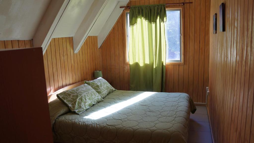 a bedroom with a bed and a window at Cabañas Pachapulay in Las Trancas