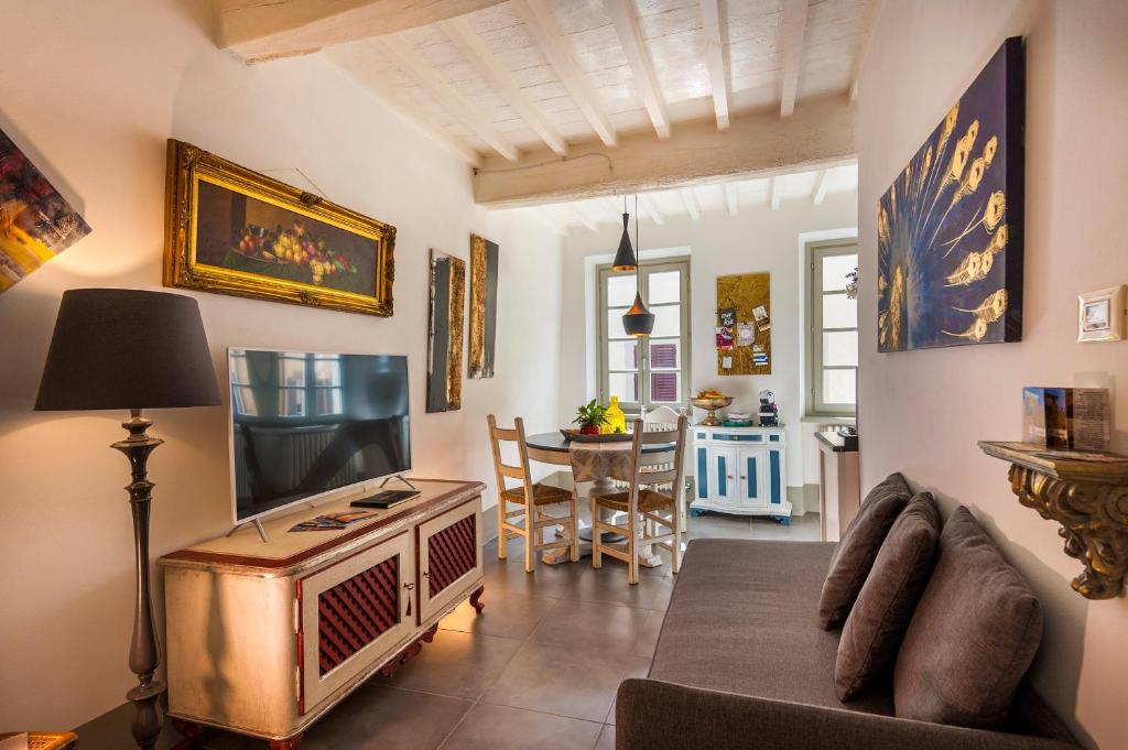 a living room with a television and a dining room at Sweet Tuscany Appartamento Gold in Arezzo
