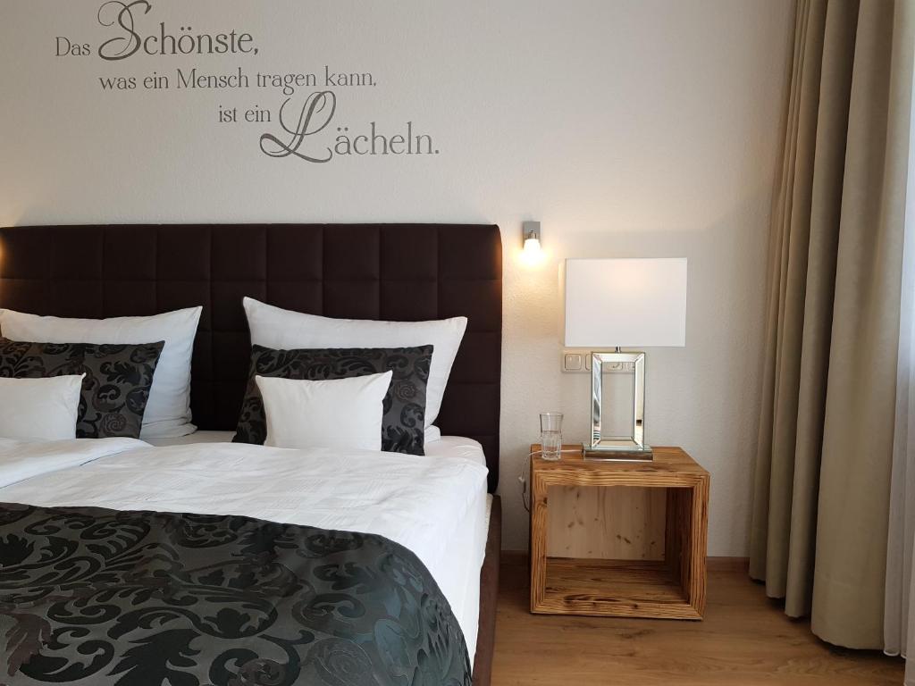 ein Schlafzimmer mit einem Bett und einem Tisch mit einer Lampe in der Unterkunft Hubertushof in Jungholz