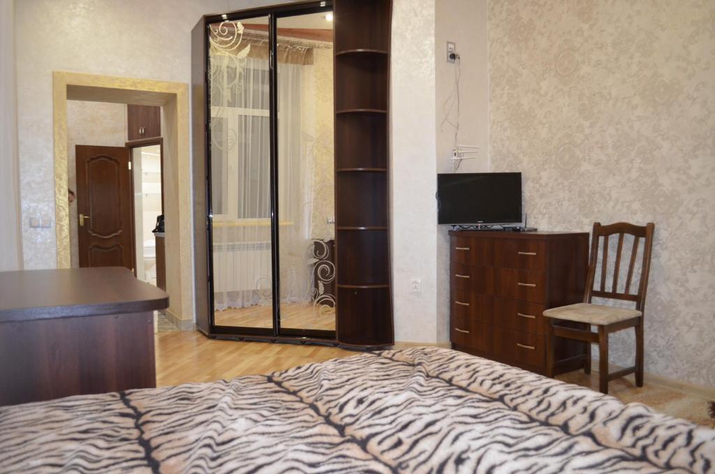 リヴィウにあるApartamenty Novyi Svitのベッドルーム(ベッド1台、デスク、鏡付)