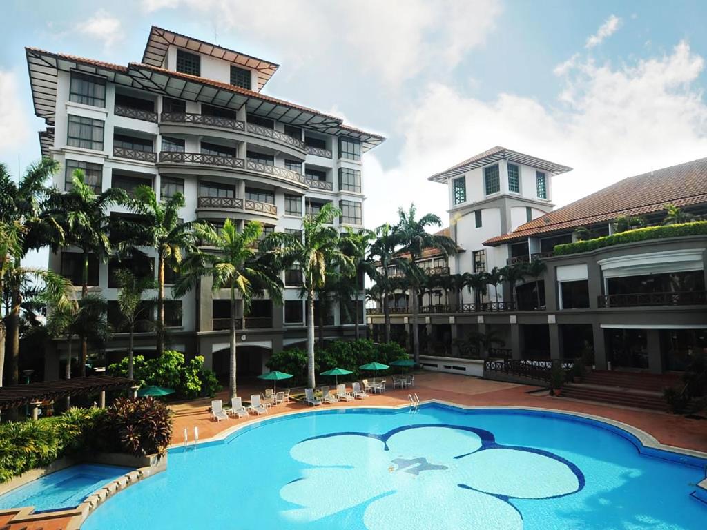 a resort with a swimming pool in front of a building at Mahkota by The Bliss Malacca in Malacca
