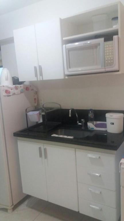 a kitchen with a sink and a microwave at Flats Jaqueira Prime in Recife