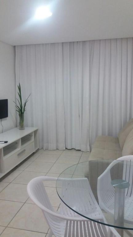 a living room with a glass table and white chairs at Flats Jaqueira Prime in Recife