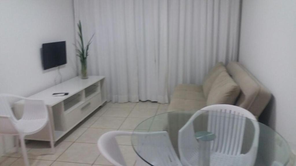 a living room with a glass table and a couch at Flats Jaqueira Prime in Recife