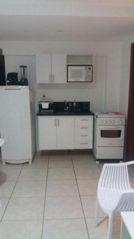 a kitchen with a white refrigerator and a microwave at Flats Jaqueira Prime in Recife