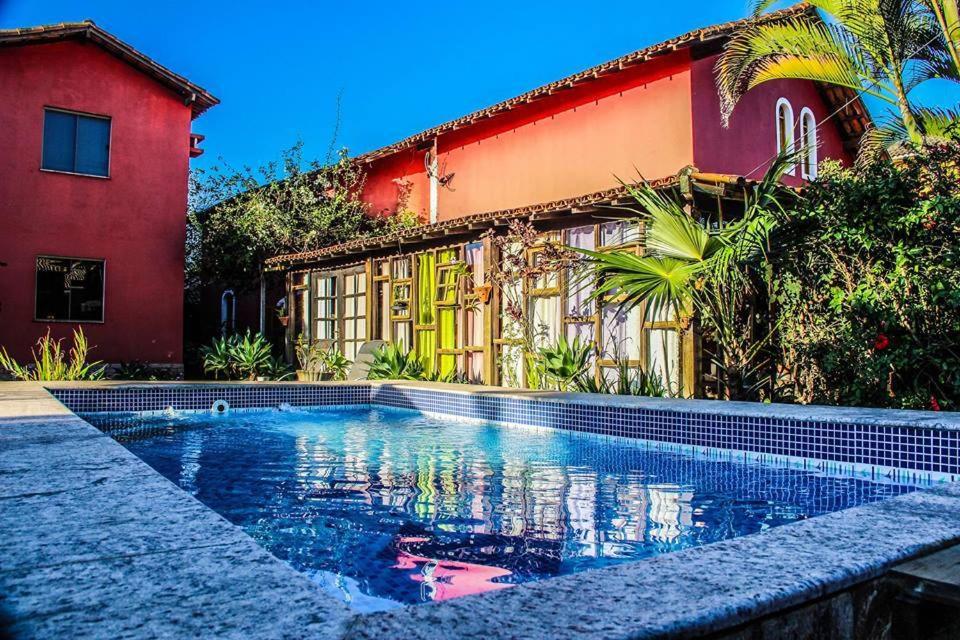 uma piscina em frente a uma casa em Skandalo Pub Pousada em Rio das Ostras