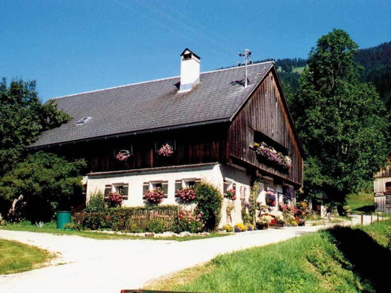 une grange avec des fleurs devant elle dans l'établissement Ferienhaus Nelln, à Reith