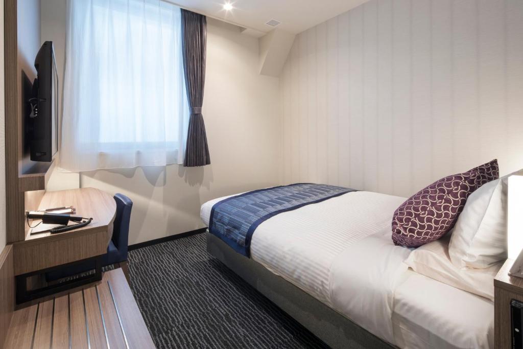a hotel room with a bed and a window at Hotel Mystays Gotanda Station in Tokyo