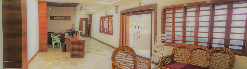 un corridoio con sedie e un tavolo in una stanza di Hotel Chela a Kumbakonam