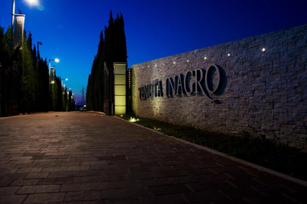 Una pared de ladrillo con la palabra marco en ella por la noche en Tenuta Inagro, en San Severo