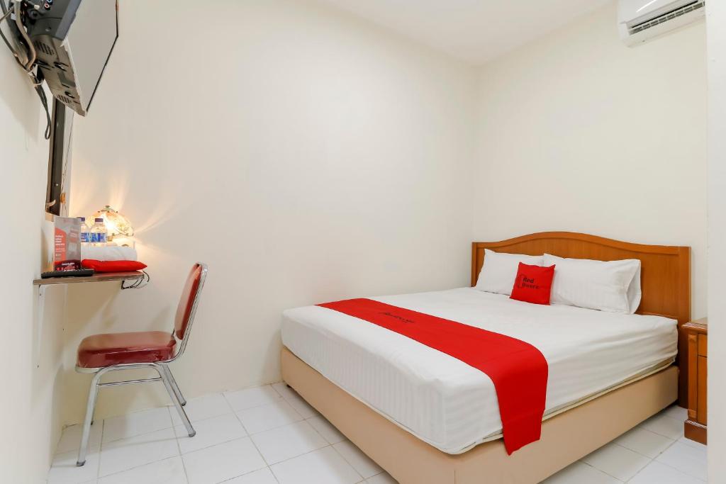 a bedroom with a bed and a chair in it at RedDoorz Plus near Ciputra World Kuningan 2 in Jakarta