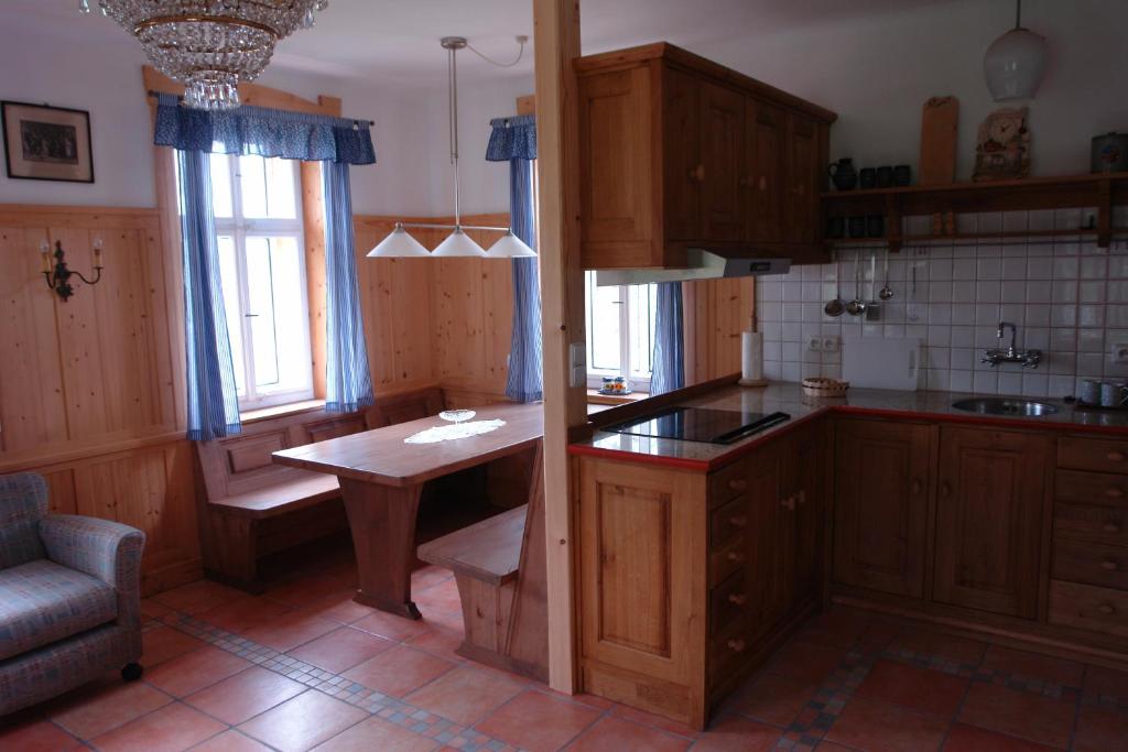 una cocina con armarios de madera y una mesa. en Chata Hugo - 3 Retreat Apartments en Tanvald