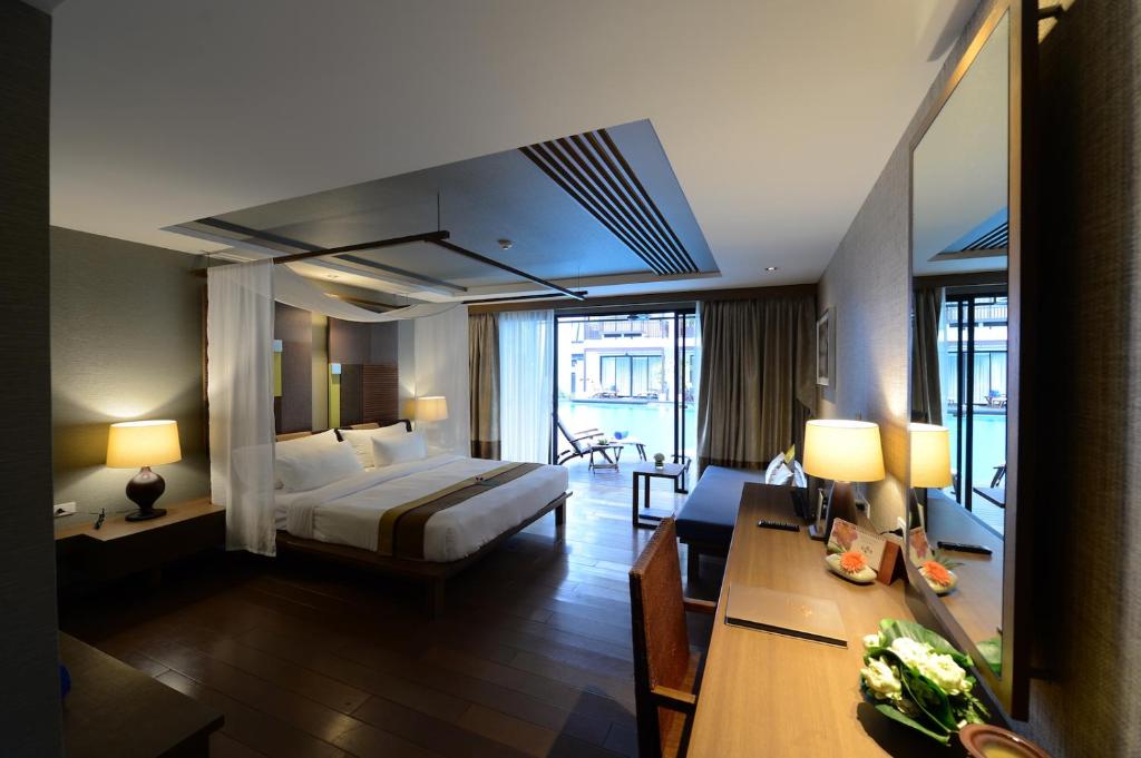 a large hotel room with a bed and a desk at Rarin Jinda Wellness Spa Resort in Chiang Mai