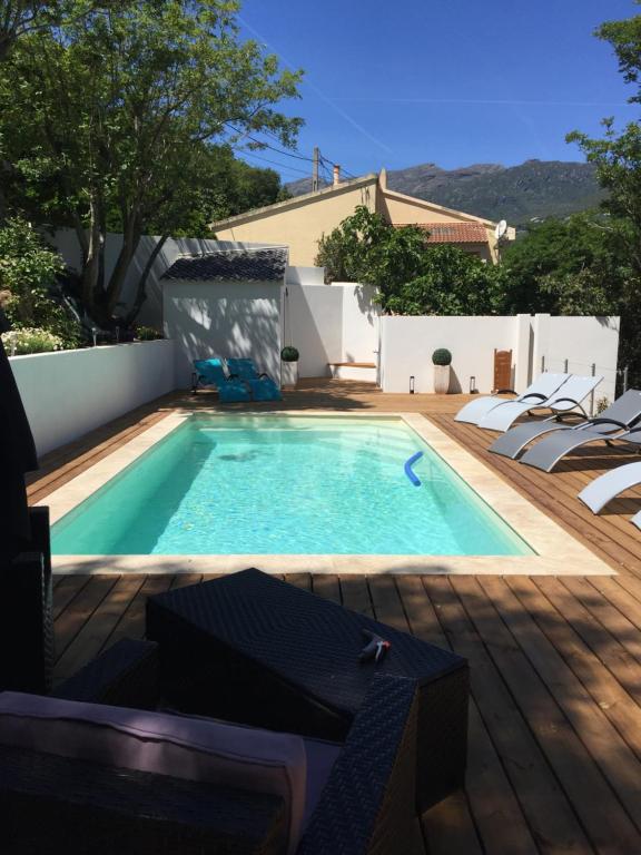 - une piscine dans un jardin avec une terrasse en bois dans l'établissement Camping les Orangers, à San-Martino-di-Lota