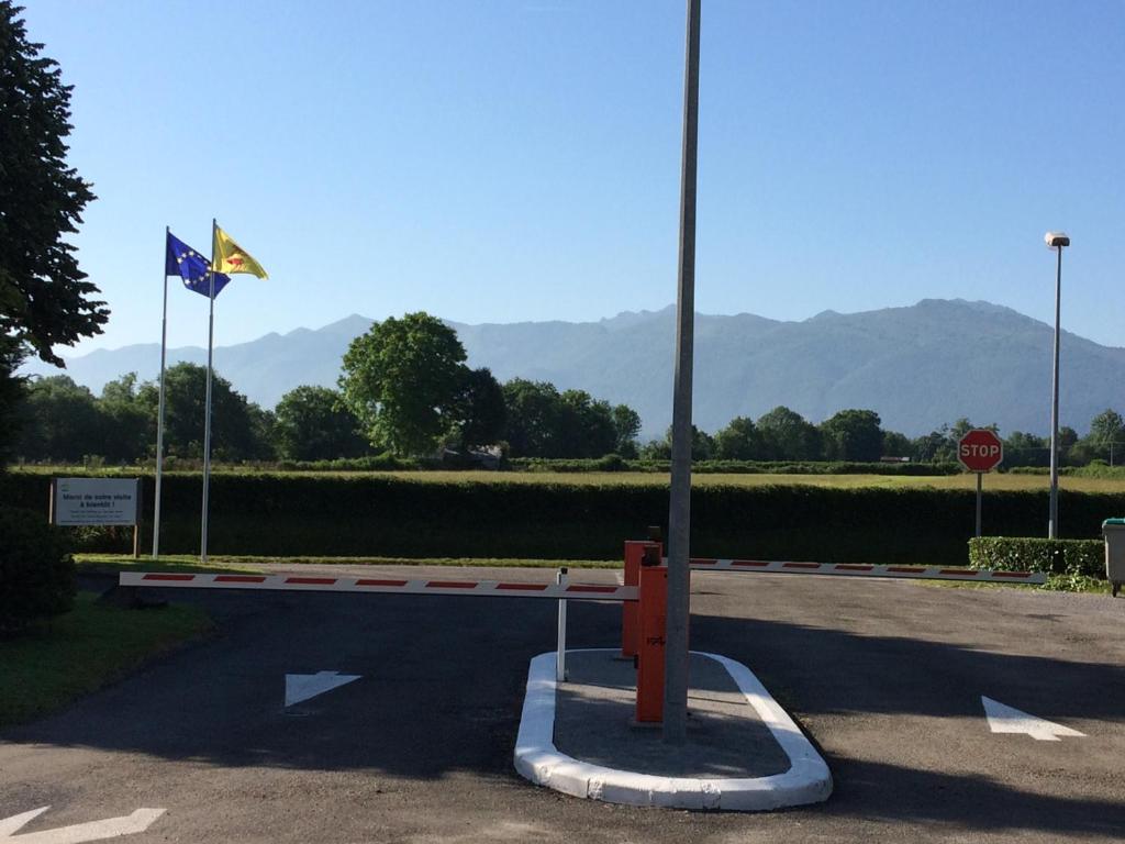 una calle con una señal de stop y dos banderas en Camping Pyrénées Nature, en Oloron-Sainte-Marie