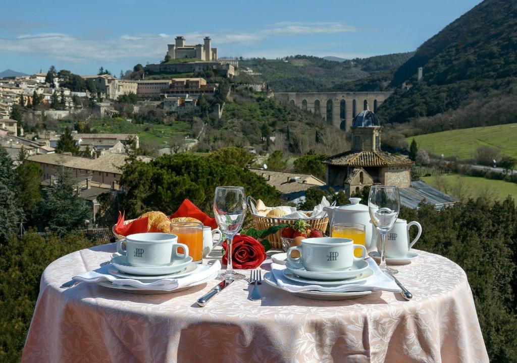 a table with a plate of food and drinks on it at Albornoz Palace Hotel in Spoleto