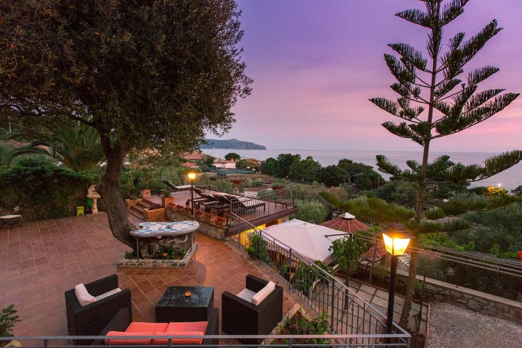 een patio met banken en tafels en uitzicht op de oceaan bij B&B Incanto del Mare in Palinuro