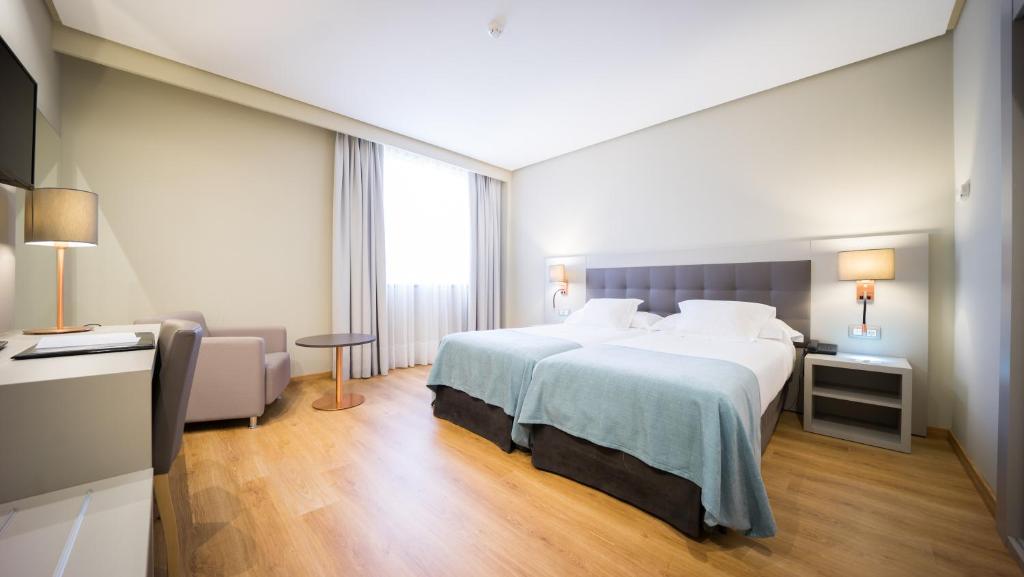 ein Hotelzimmer mit einem großen Bett und einem großen Fenster in der Unterkunft Mercure Carlton Rioja in Logroño